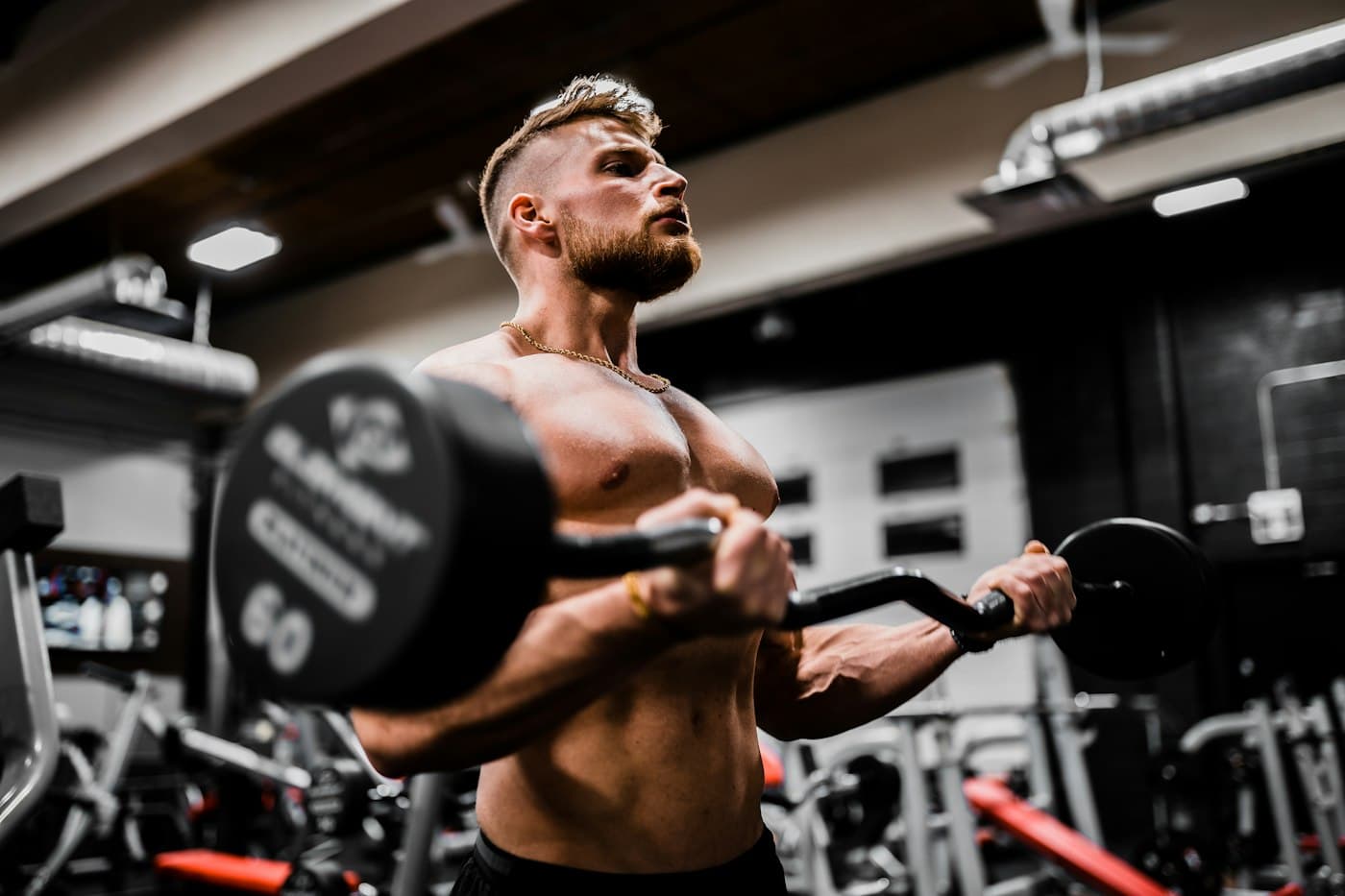 Atleta treinando com halteres em academia com iluminação dramática